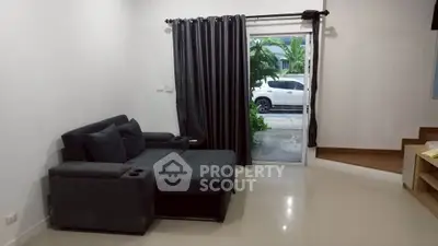 Modern living room with sleek black sofa and large window view