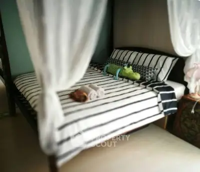 Cozy bedroom with striped bedding and decorative pillows in a serene setting