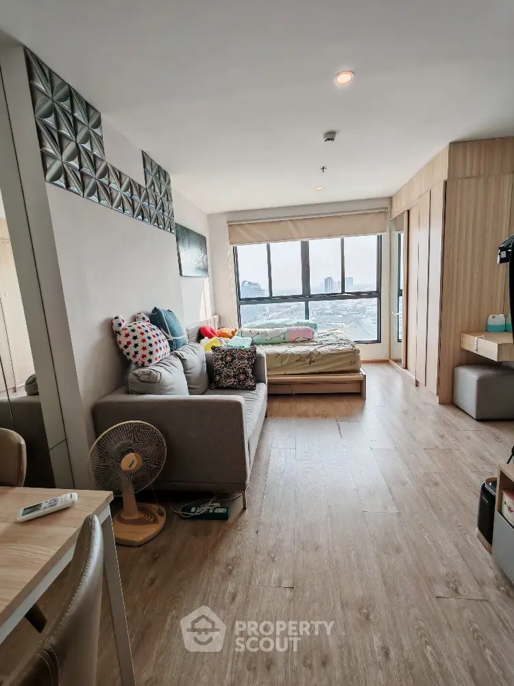 Modern living room with large windows and stylish decor offering stunning city views
