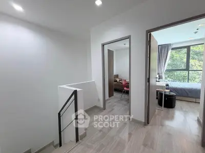 Modern interior with bright bedroom and sleek staircase, showcasing contemporary design and natural light.