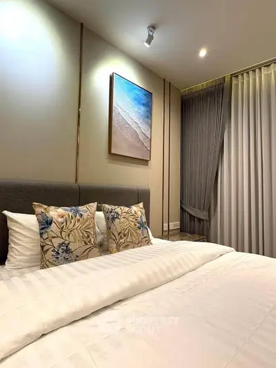Luxurious bedroom with elegant decor and cozy bedding in modern apartment.