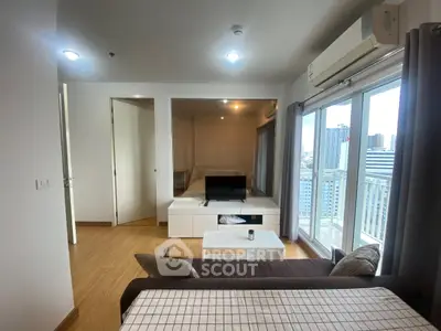 Modern living room with city view, featuring sleek furniture and large windows for natural light.