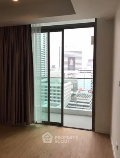 Modern apartment with city view from floor-to-ceiling windows and balcony access.