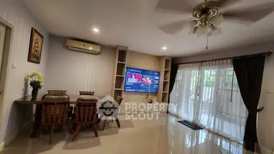 Spacious living room with modern decor and large TV, perfect for relaxation.