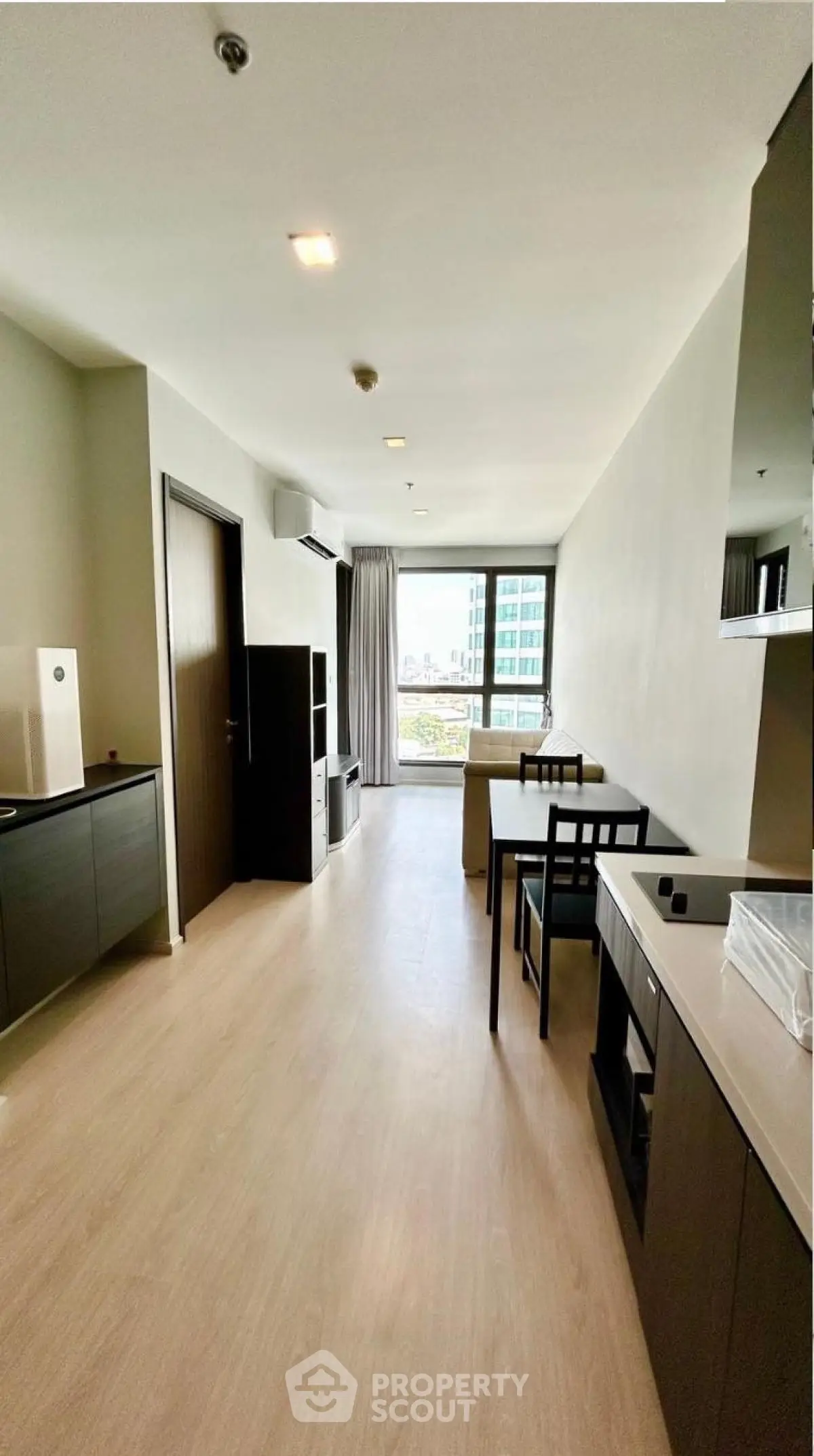 Modern apartment interior with open layout and city view, featuring sleek furniture and natural light.