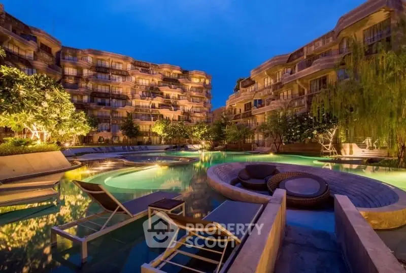 Luxurious apartment complex with stunning pool and ambient lighting at dusk.