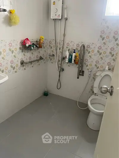 Spacious bathroom with floral tiles and modern fixtures, ideal for comfort and accessibility.