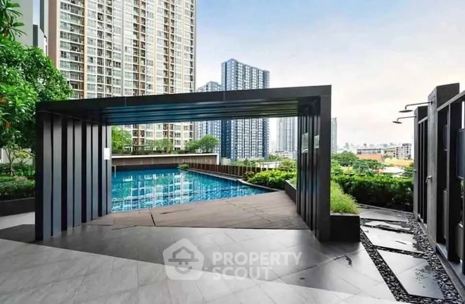 Luxurious modern pool area with city skyline views in high-rise residential complex.