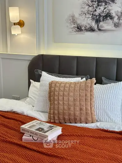 Cozy bedroom with plush pillows and warm lighting, perfect for relaxation and comfort.