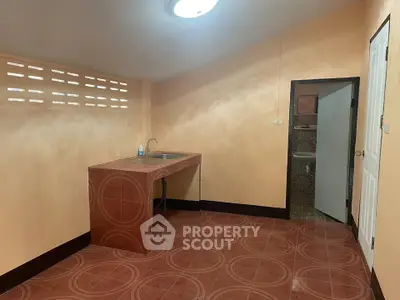 Simple kitchen with red tile flooring and compact sink area