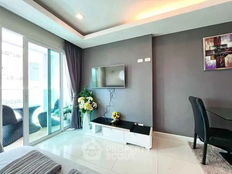 Modern living room with sleek TV setup and balcony view