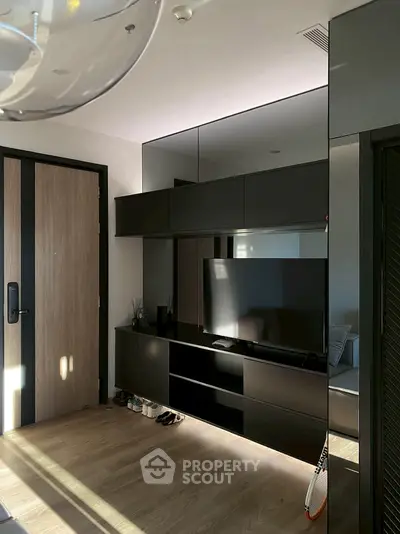 Modern living room with sleek black entertainment unit and wooden flooring