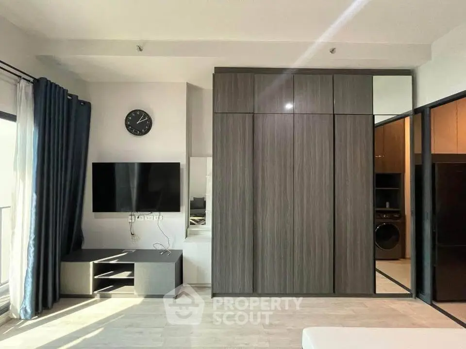 Modern living room with sleek TV setup and stylish wardrobe