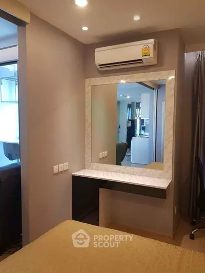 Modern bedroom with air conditioning and stylish vanity mirror in a cozy apartment.