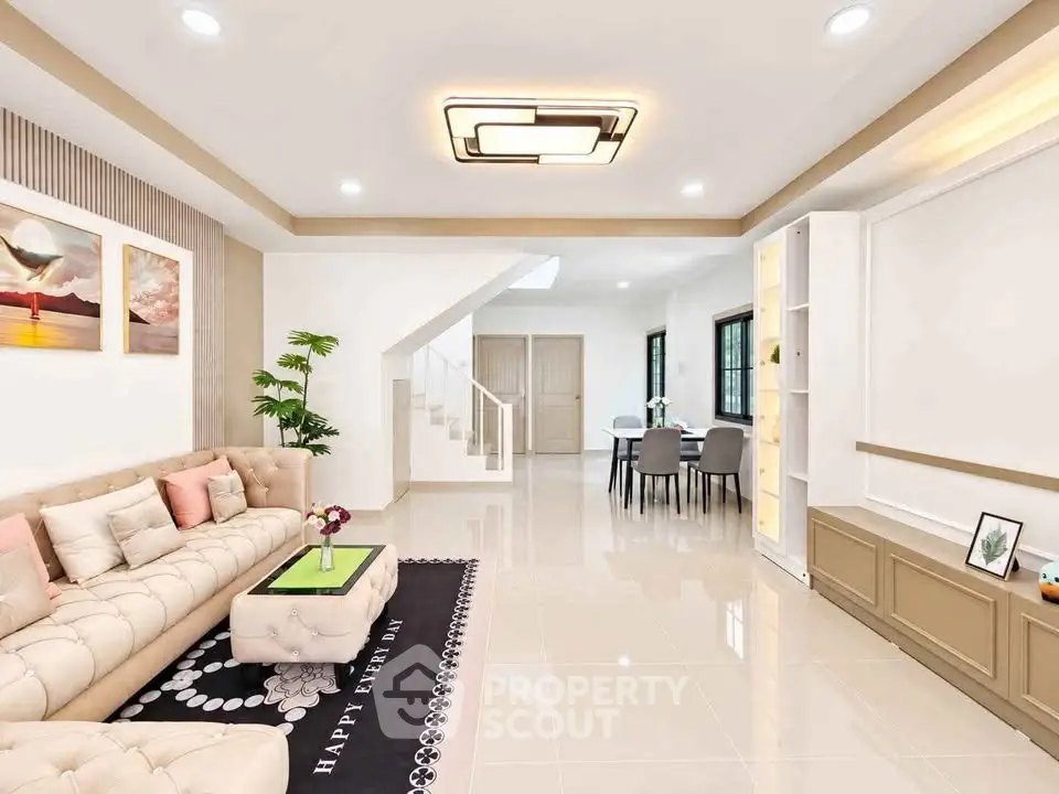 Spacious modern living room with elegant decor and open dining area, perfect for family gatherings.