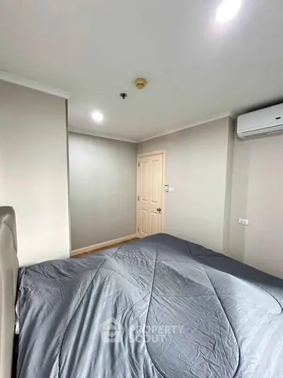 Spacious bedroom with modern decor and air conditioning in a stylish apartment.