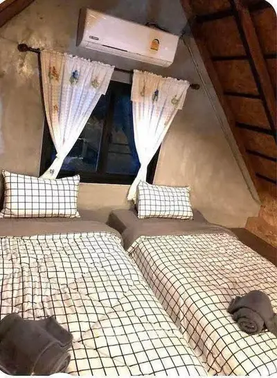 Cozy attic bedroom with twin beds and air conditioning, perfect for a comfortable stay.