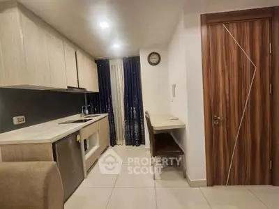 Modern kitchen with sleek cabinetry and integrated appliances in a cozy apartment setting.