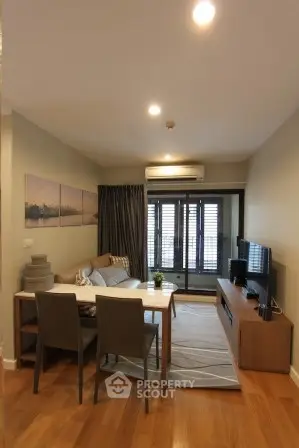 Modern living room with cozy seating and stylish decor in a well-lit apartment.