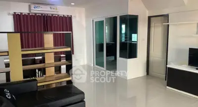 Modern living room with sleek furniture and open layout, featuring a stylish partition and elegant curtains.