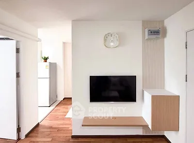 Modern living room with wall-mounted TV and stylish wooden flooring