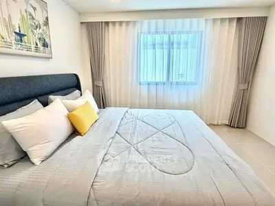 Spacious and elegant bedroom with modern decor and large window for natural light.