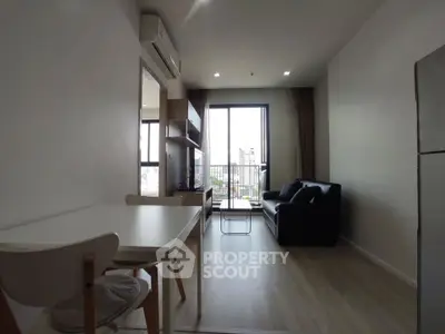Modern living room with city view, featuring sleek furniture and natural light.