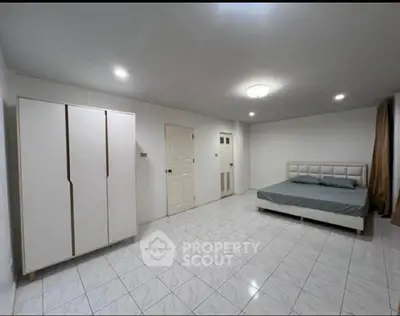 Spacious bedroom with modern minimalist design and ample natural light
