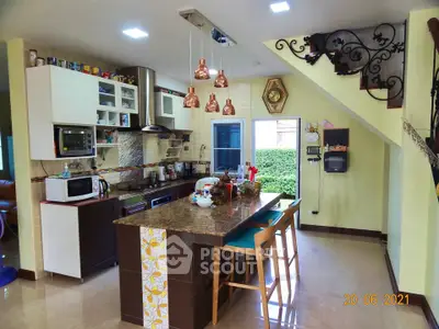 Charming kitchen with island, modern appliances, and stylish lighting in a cozy home setting.