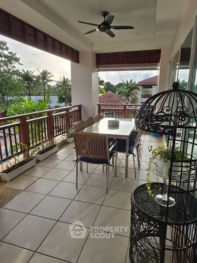Spacious balcony with dining set and lush garden view, perfect for outdoor relaxation.