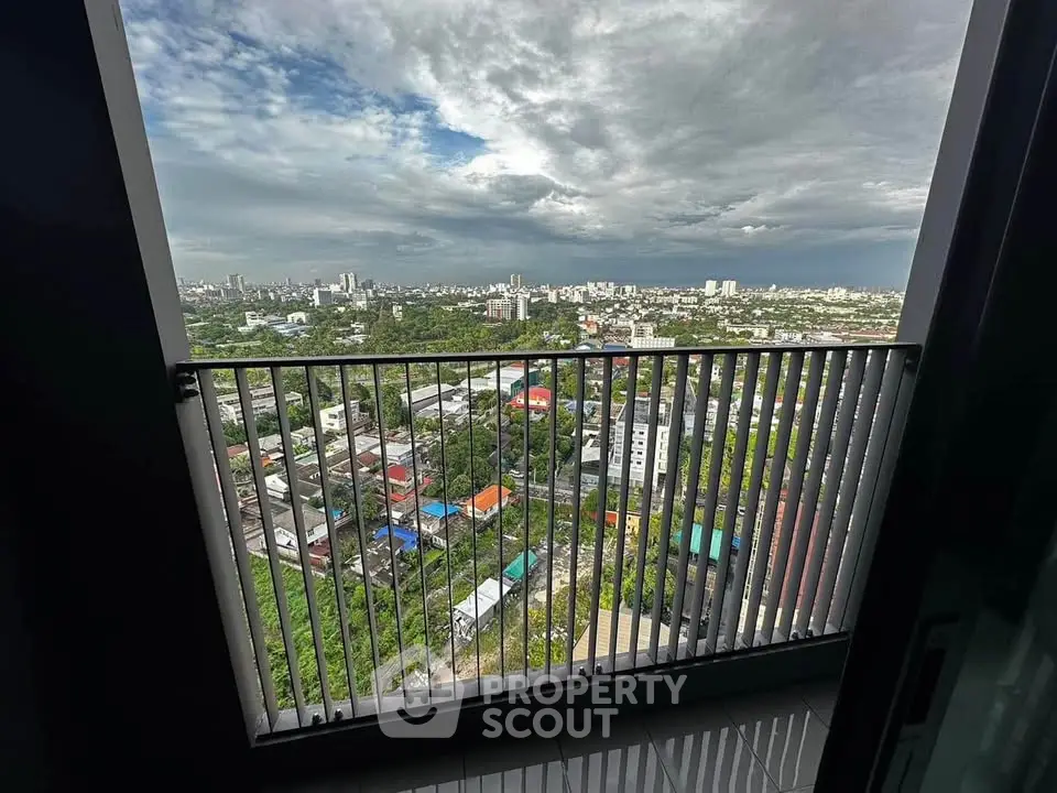 Stunning high-rise balcony view overlooking vibrant cityscape and lush greenery.
