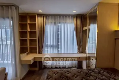 Elegant bedroom with built-in shelves and large window with sheer curtains.