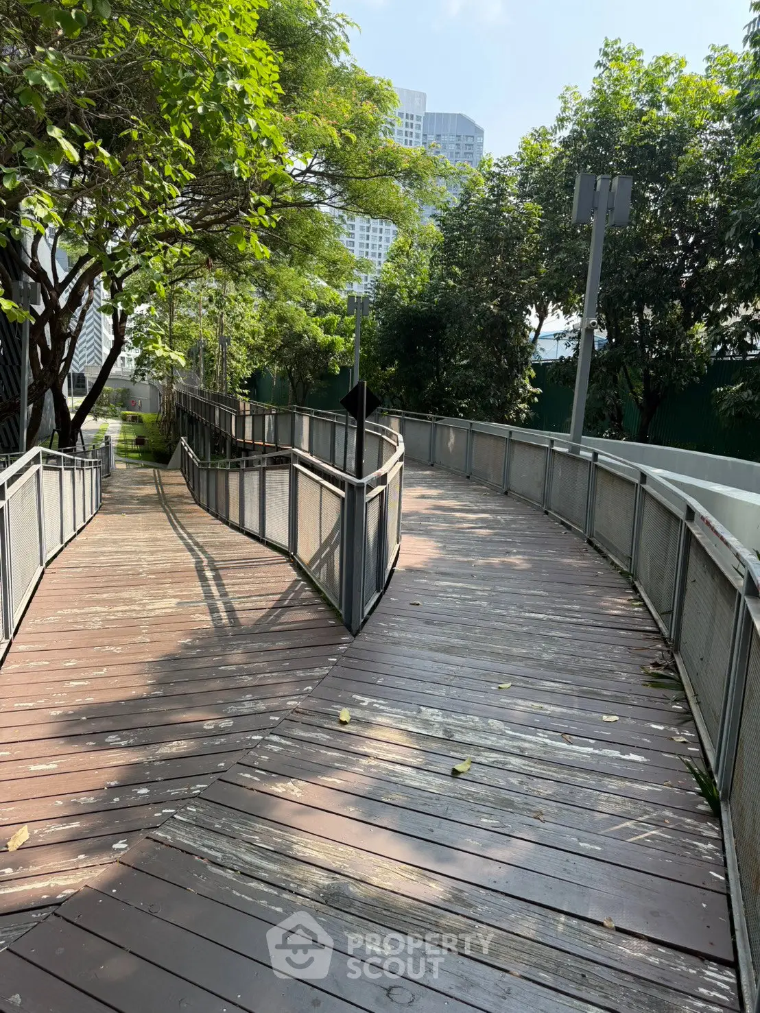 Charming wooden pathway surrounded by lush greenery in urban setting, perfect for serene strolls.