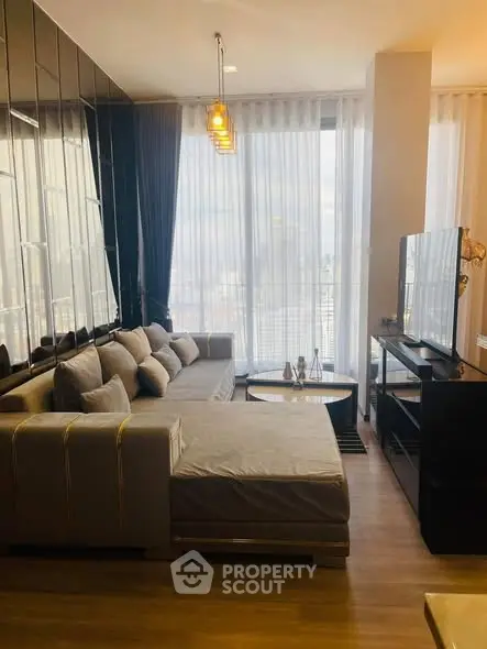 Modern living room with stylish decor and large windows offering city views.