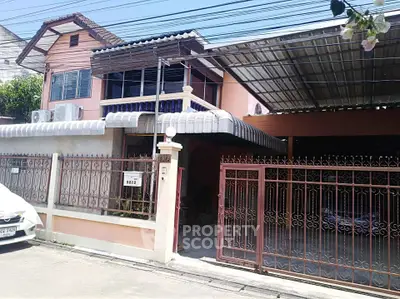 Charming two-story house with gated entrance and covered parking in a suburban neighborhood.