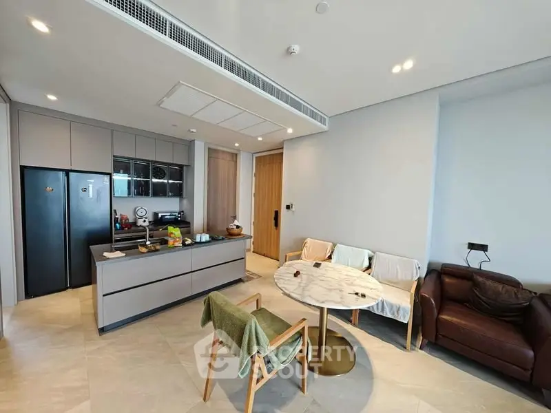 Modern open-layout kitchen and living area with sleek design and cozy seating.