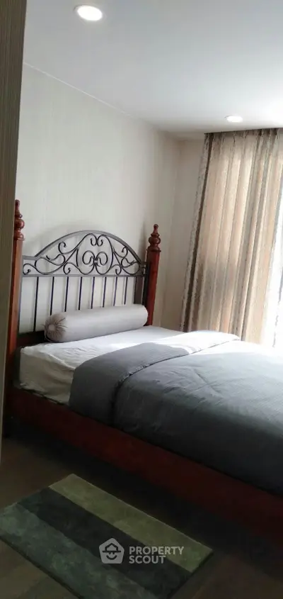 Cozy bedroom with elegant wooden bed frame and soft lighting, perfect for relaxation.