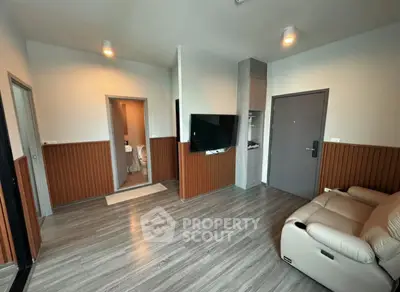 Modern living room with sleek flooring and wall-mounted TV