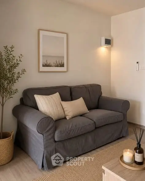 Cozy living room with gray sofa, decorative pillows, and warm lighting.