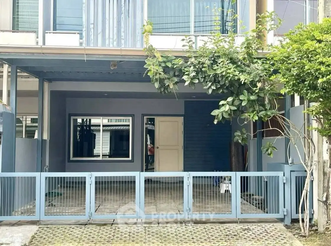 Charming townhouse exterior with gated entrance and lush greenery, perfect for modern living.