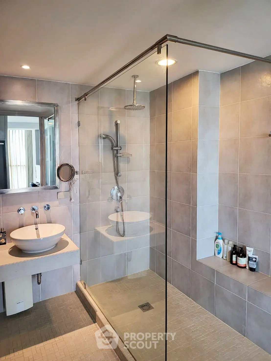 Modern bathroom with glass shower and stylish sink in luxury apartment