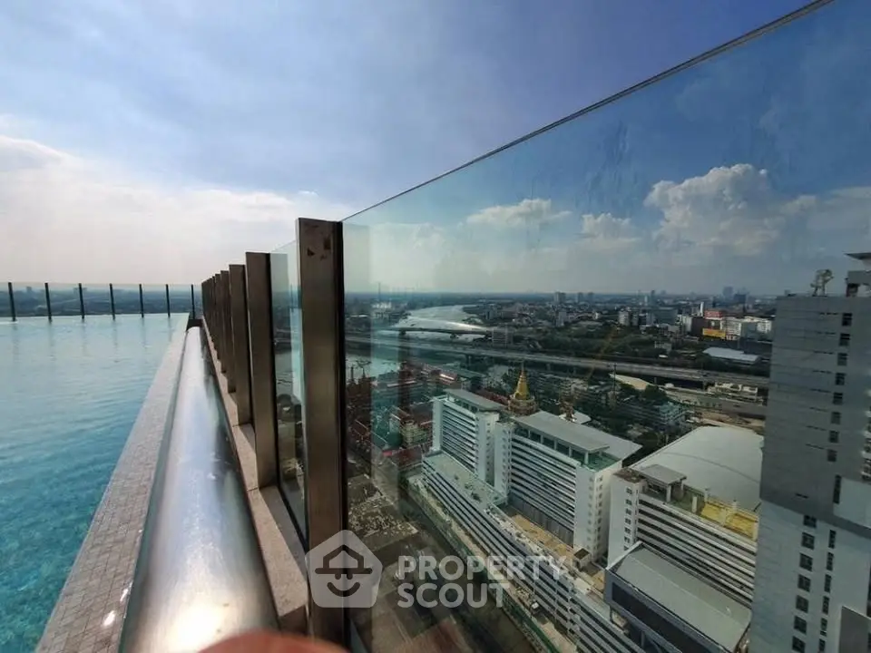 Stunning rooftop pool with panoramic city view and glass railing, perfect for luxury living.