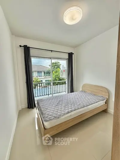 Bright bedroom with modern decor and balcony view in a stylish apartment.