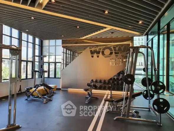 Modern gym with large windows and state-of-the-art equipment in a luxury building.