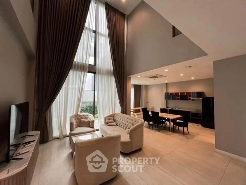 Luxurious high-ceiling living room with elegant furniture and large windows in modern apartment.