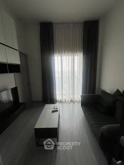 Modern living room with floor-to-ceiling window and sleek furniture