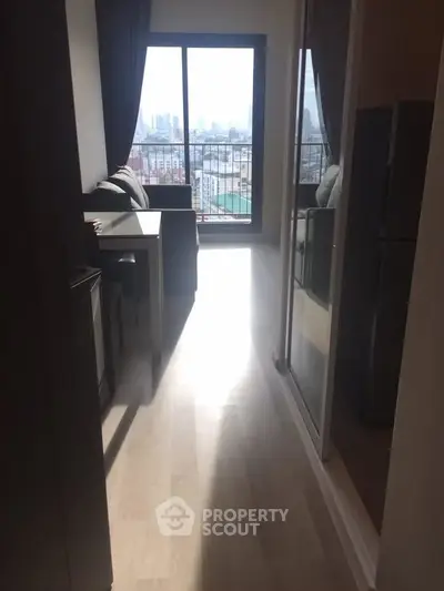 Modern apartment with city view and balcony, featuring sleek interior design and natural light.