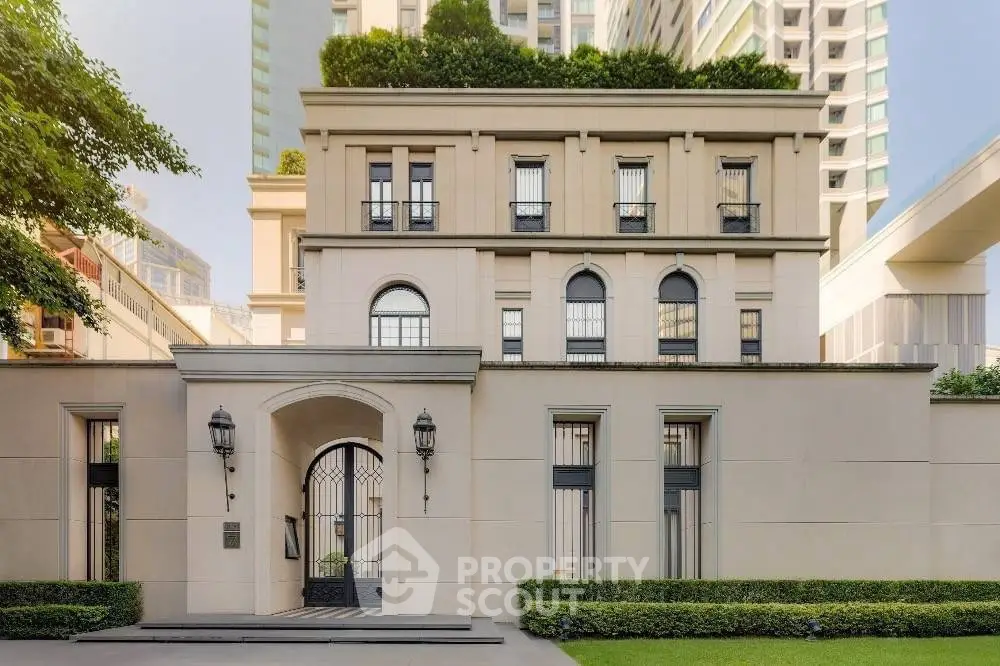 Elegant multi-story building with classic architecture and lush greenery in urban setting.