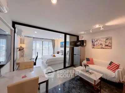 Modern open-plan living room with stylish decor and city view, featuring a cozy bedroom and sleek kitchen area.