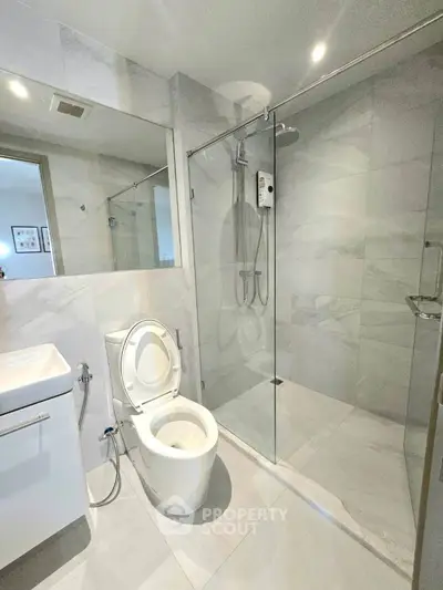 Modern bathroom with glass shower and sleek fixtures in a contemporary home.